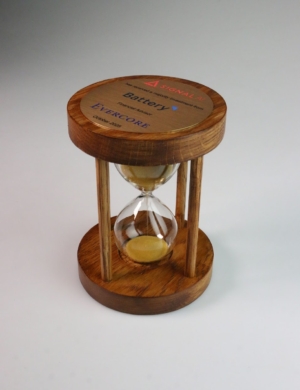 Custom hourglass deal toy symbolising timing and value creation in a completed financial transaction.