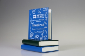 Bespoke book-themed financial tombstone marking British Council education business sale.